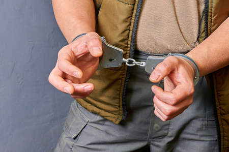 mens hands in metal handcuffs