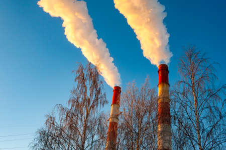 white smoke is coming out of the pipes in the blue skyの写真素材
