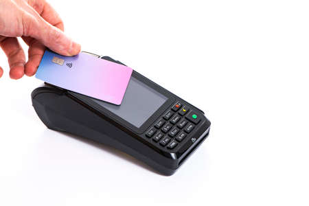Attached plastic card to the payment terminal with a mans hand on a white isolated background, copy...