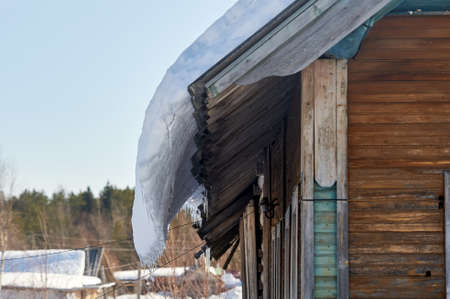 a block of ice hangs from the roof of the house