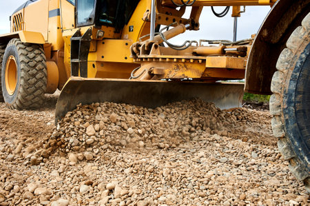 the grader blade levels the rubble at the construction siteの写真素材