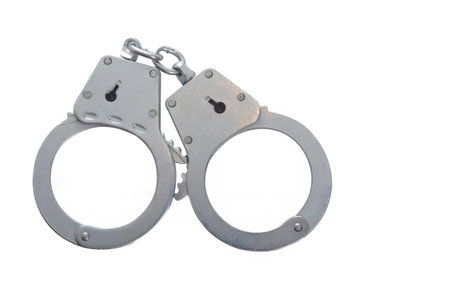 Metal handcuffs on a white isolated background, copy space