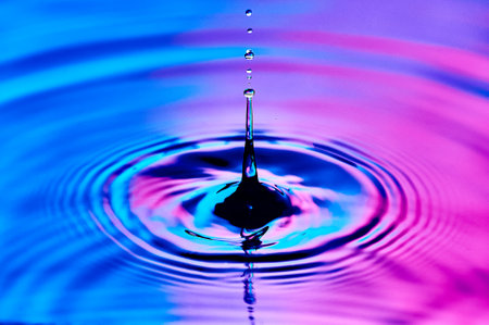 a drop of water falling into the water and creating wavesの写真素材