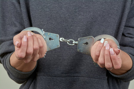 womens hands are handcuffed in close-upの写真素材