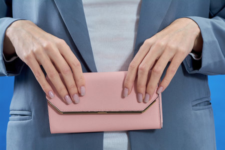 Womens hands hold a pink purse