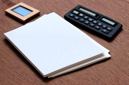 Blank business card with calculator and photo frame on wooden background.の素材