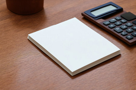 Blank business card on wooden table with calculator and cup of coffeeの素材