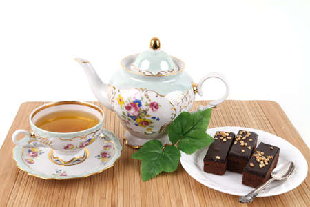 Teapot and cup of tea with 3 brownies on white backgroundの写真素材