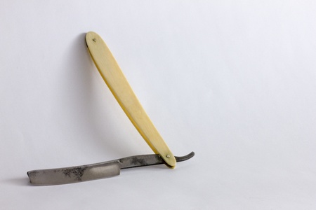 Macro of an antique straight razor isolated on a white