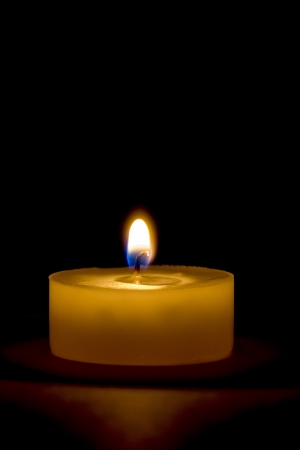 Tea light candle Isolated on black - macroの写真素材