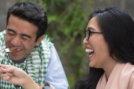 couple of young asian women and man laughing while having lunc and dinner