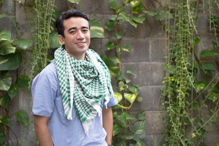 A muslim man stand and pose in front of the camera