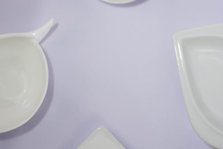 Flat lay of white plate, bowl, isolated in white or purple fabric, simple minimalist template...
