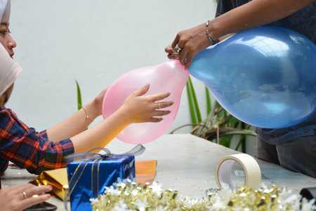 close up portrait of women hand holding red balloon and wrapping gift preparing birthday surprise...