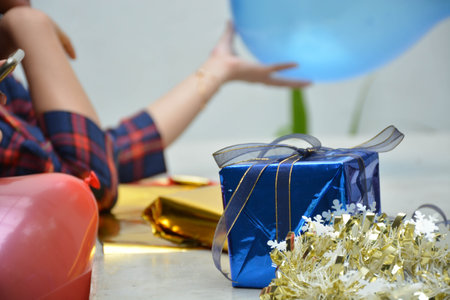close up portrait of women hand holding red balloon and wrapping gift preparing birthday surprise...