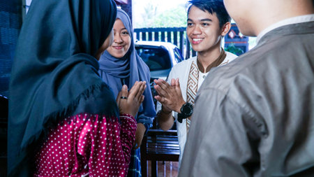 close up shot of Muslim couples visiting their family or friend home while shaking hand and hugs on...