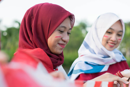 portrait of young asian muslim woman group preparing prepare flags to decorate and celebrate...