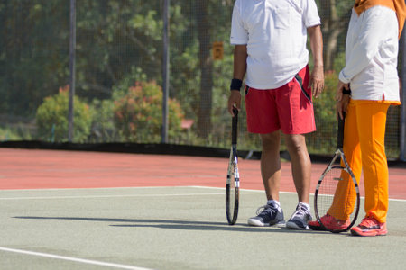 Portrait of an active asian muslim senior couple standing at outdoors tennis hard court and ready to...