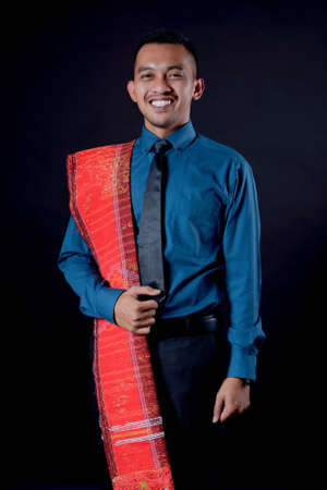 portrait of beautiful indonesian man wearing traditional batak costume. batak modern traditional...