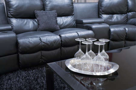 black executive leather home teather chairs with wine glasses on tray on black table