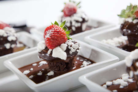 chocolate mudcakes with strawberry on white plates chocolate mudcakes with strawberry on white plates