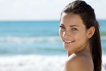 Beautiful young woman smiling at the beachの写真素材