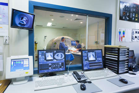 MRI machine and screens with doctor and nurse