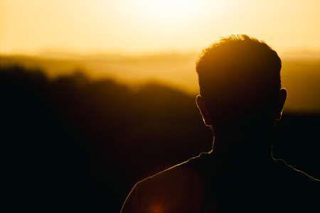 A man watching a beautiful sunset over the Sunshine Coast hinterland.  Located at Mapleton Falls, QLD, Australia.の写真素材