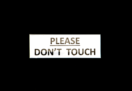 Do not touch signboard with on black backgroundの写真素材