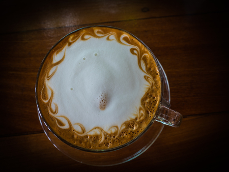 Top view latte art coffee on wood tableの写真素材