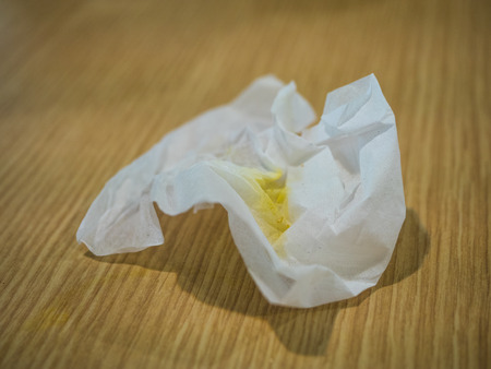 crumpled tissue paper on wood and blurry backgroundの写真素材