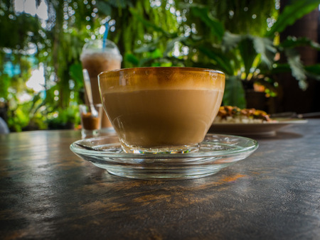 Side view latte art coffee on wood table, low keyの写真素材