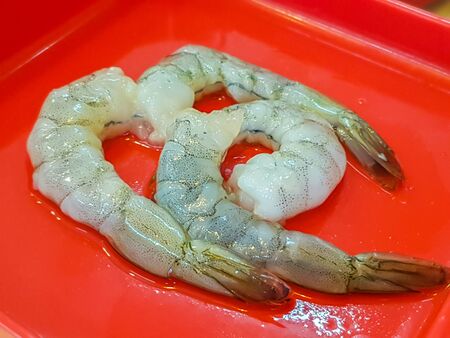 Close up of fresh shrimps on plate for cookingの写真素材
