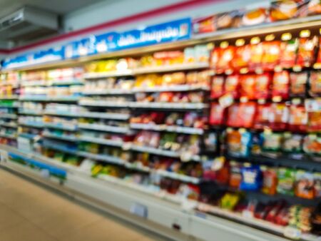 lurred abstract of chips, snacks on shelves display at mini mart storeの写真素材