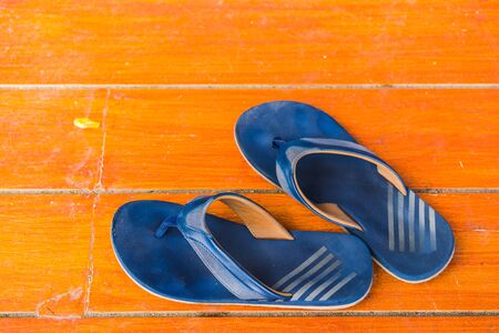 Old, dirty rubber shoes on the orange floor. Top view and copy space.の写真素材