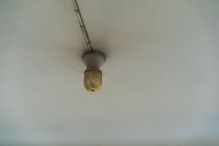 Old Light hanging from a ceiling with dust paintの写真素材