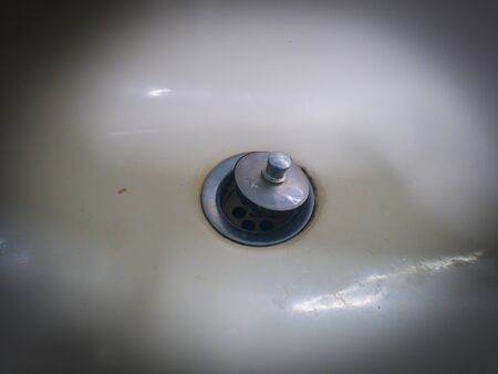 Abstract Silver rusty sink hole in the white ceramic sin, lowkeyの写真素材