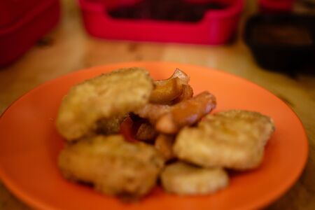 The Homemade Crispy Popcorn Chicken on orange plateの写真素材