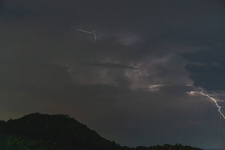The Storm lightning strikes in mountains during a thunderstorm at night. Beautiful dramatic viewの写真素材
