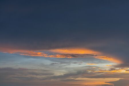 The Bright orange and gold colors of the sunset sky. Summer sky with clouds during the sunsetの写真素材