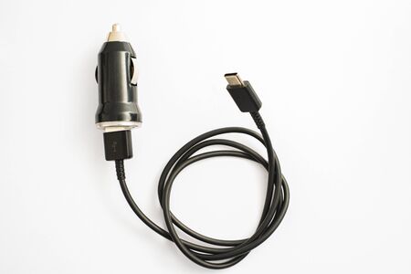 The black car charger with USB output connection cable. A photo taken on a black car charger with...