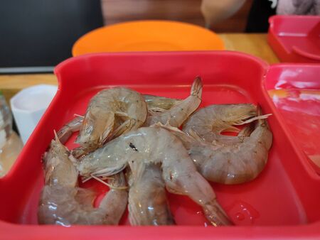 The fresh shrimp on red plate for cookingの写真素材