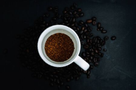 The Abstract frosted glass image on Top view of Instant coffee in cup on dark background with beansの写真素材