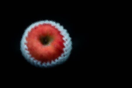 Abstract frosted glass image on A fresh red apple with Shockproof sponge against black background with space for textの写真素材