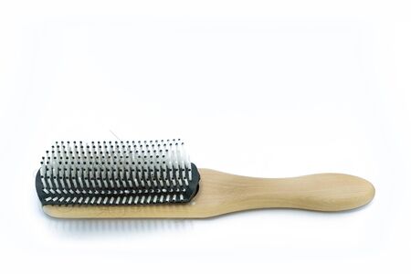 A Wooden handle Comb with hairs loss on white background.の写真素材