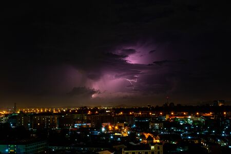 The Cloudy with Bright lightning bolt strikes in the rural landscape of small cityの写真素材