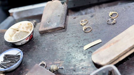 Goldsmith's bench with some golden rings in process - selectived focus