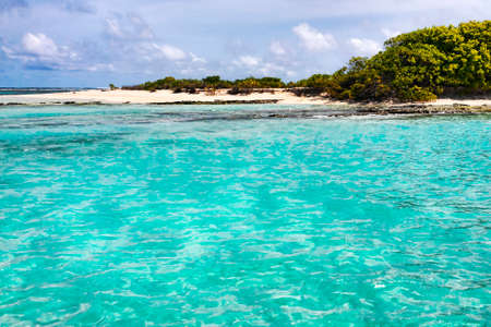 Approach to an uninhabited atoll in the Maldives islands with white sand and coral reefsの写真素材