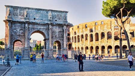 Rome, Italy - June 30, 2018: View of the Arch of Constantine and the Colosseum from Via dei Fori Imperiali, around some tourists and photographers  enjoy the beautiful evening in Rome.のeditorial素材