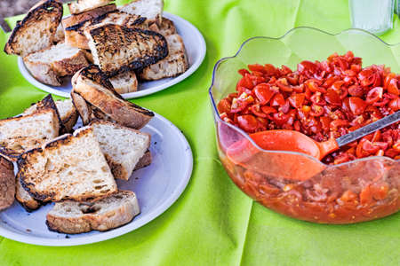 Table set to preparation of the typical Italian bruschetta with toasted bread, garlic and extra-virgin olive oil and diced tomatoesの写真素材